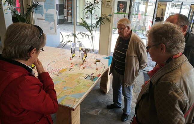 Vier mensen kijken naar een kaart van Almere die op een tafel uitgespreid ligt